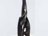 a black sculpture on a white table with a white background