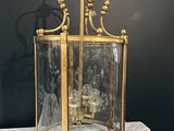 an antique brass and glass lantern on a marble table