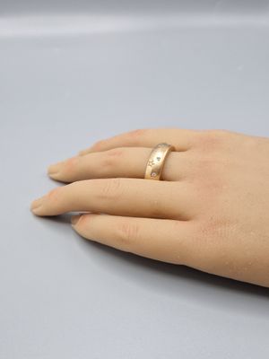 a woman ' s hand with a gold ring on it