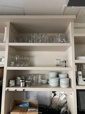 de nombreux plats et verres sur les étagères de la cuisine