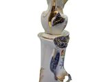 a white vase with a blue and gold decoration on it