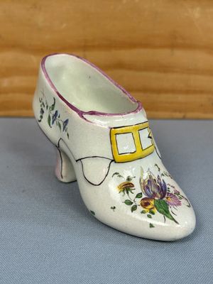 une petite chaussure blanche décorée de fleurs peintes