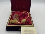 une boîte rouge contenant une pipe dorée et un mot