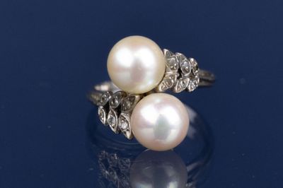une image représentant une bague en perle blanche et diamants sur un fond bleu