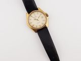 a close up of a watch on a white surface