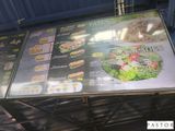 un grand panneau présentant le menu, fixé sur le côté d'un immeuble