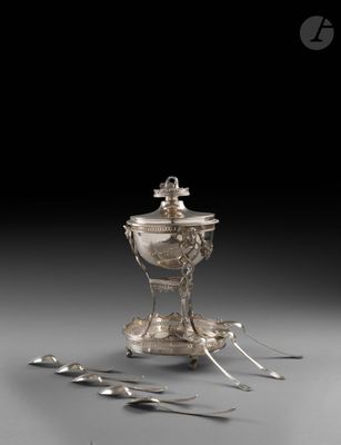 un service en argent ancien avec des cuillères et un repose-cuillères posé sur une table