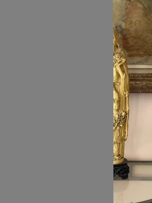une statue représentant une femme assise sur un banc
