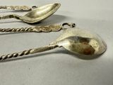 three spoons that are sitting on a table