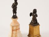 pair of bronze figurines of a boy and a girl on a pedestal