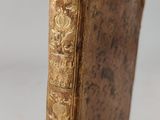 an old book sitting on top of a white surface