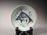 a white plate with a fish on it on a stand