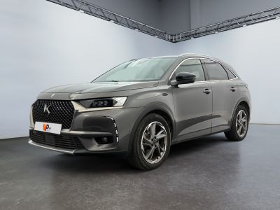 a grey car parked in a garage with a white wall
