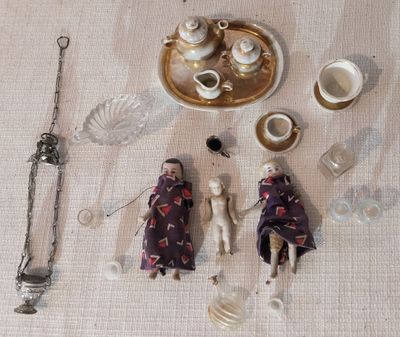 Des figurines sont disposées sur une table, accompagnées d'un plateau en argent et d'argenterie