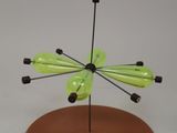 un petit objet vert posé sur un socle en bois