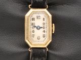 une photo d'une montre-bracelet plaquée or avec un bracelet en cuir noir