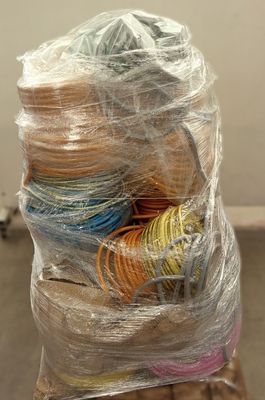 a pile of yarn wrapped in plastic on top of a pallet
