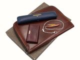 un portefeuille, un stylo et un couteau posés sur une table