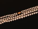 a three strand pearl necklace with a gold clasp