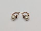 a pair of pearl earrings on a white surface
