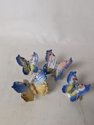 four small butterflies that are sitting on a table