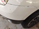 a close up of a car ' s front bumper with a denting on it