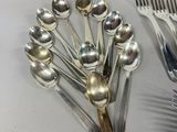a lot of silver spoons and forks on the table