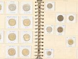 un livre ouvert sur lequel sont posées plusieurs pièces de monnaie différentes