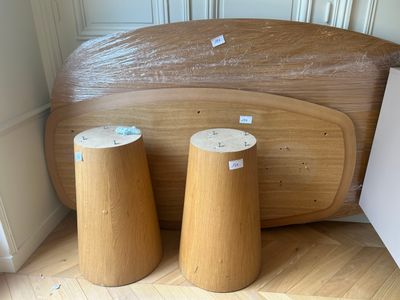 two wooden stools sitting on the floor next to a bed