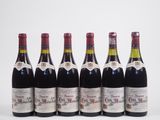 six bouteilles de vin alignées sur une surface blanche
