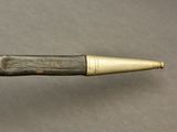 an old pipe with a brass tip on a gray surface