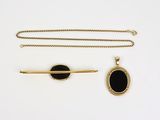 deux colliers en pierre dorée et noire et une broche plaquée or