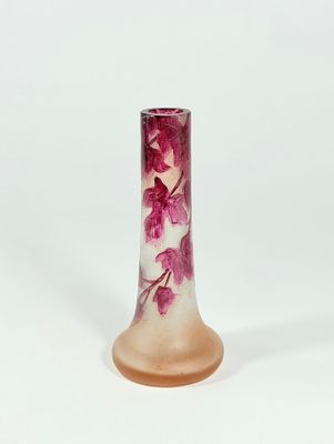 pink and white glass vase with flowers on it on a white surface