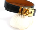 a close up of a black leather bracelet with a gold buckle