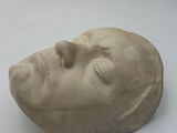 a white sculpture of a man ' s head on a white surface