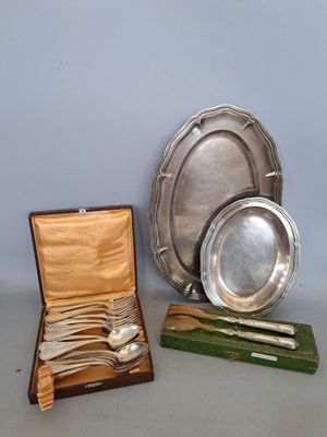 trois assiettes et cuillères en argent plaqué dans un coffret en bois posé sur une table