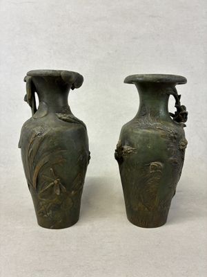 deux vases verts posés l'un à côté de l'autre sur une table