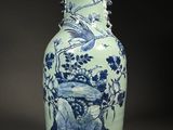 un vase bleu et blanc avec un oiseau dessus
