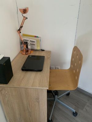a desk with a chair and a laptop on it