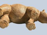 a brown teddy bear that is laying down on the ground