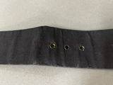 the belt is black and has three gold buttons on it
