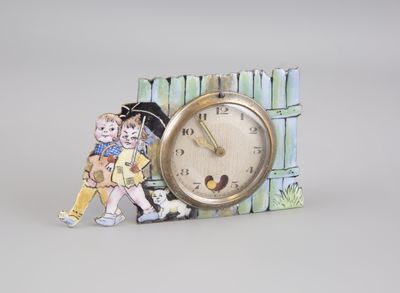 a small clock with a picture of a boy and a girl