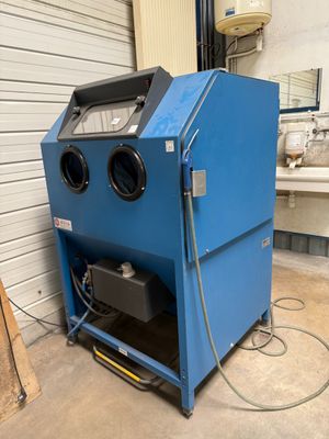 an image of a blue machine is sitting in a garage