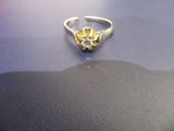 une bague en or ornée d'une fleur, posée sur une table