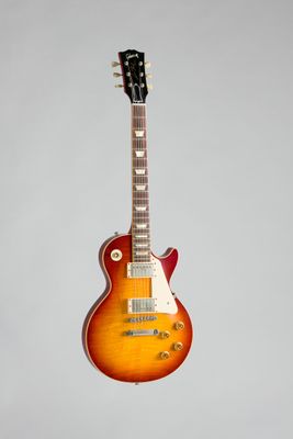 une guitare électrique accrochée à un mur sur fond blanc
