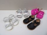 several pairs of baby shoes are lined up on a white surface