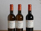 trois bouteilles de vin posées sur une table en bois