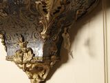 a silver and gold clock hanging on the wall