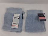 pair of light blue towels on a white surface with a price tag