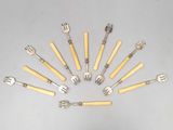 Plusieurs fourchettes et cuillères sont disposées en cercle sur une table